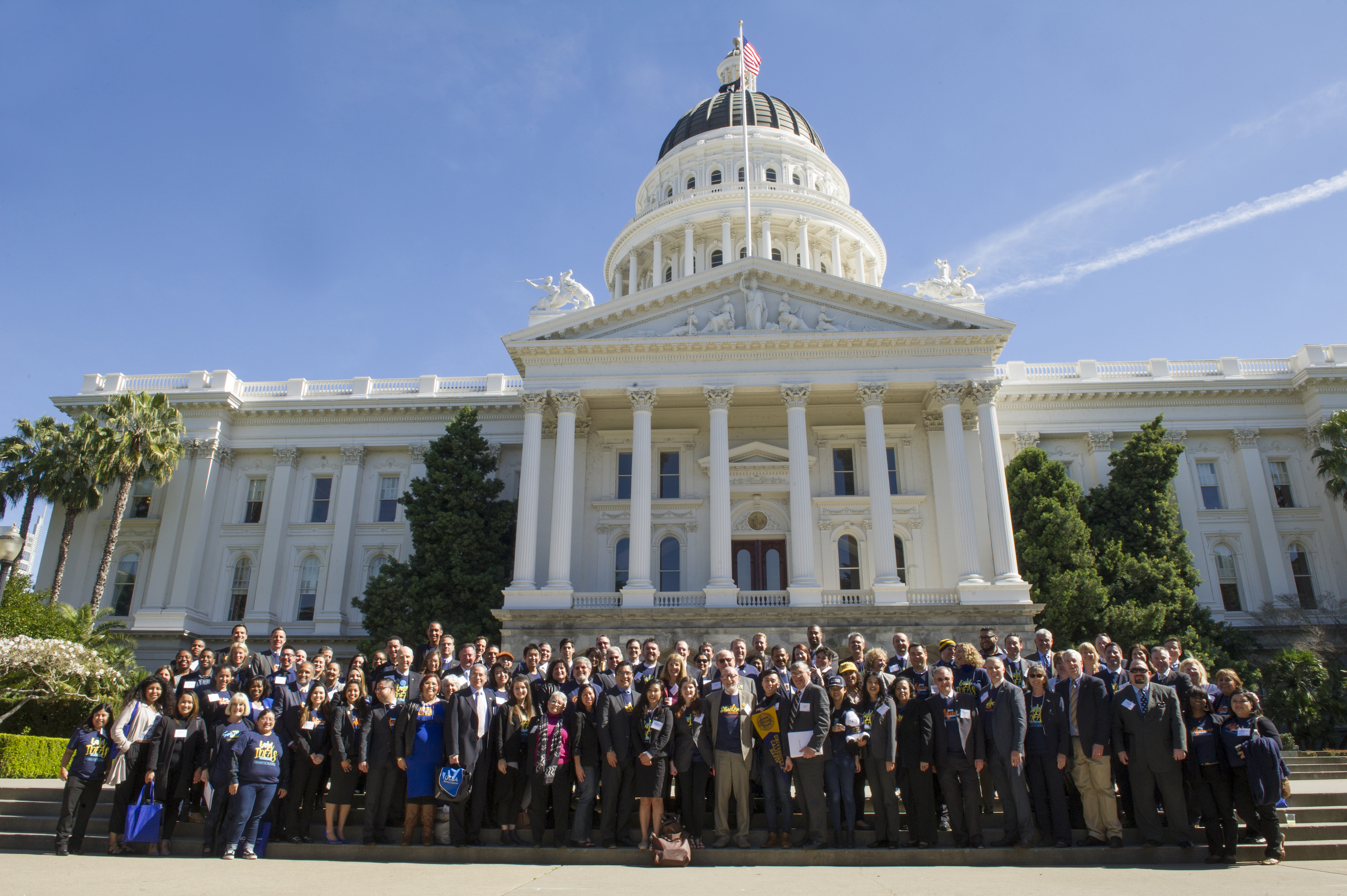 About 100 people stand in front of California capitol building for UC day.