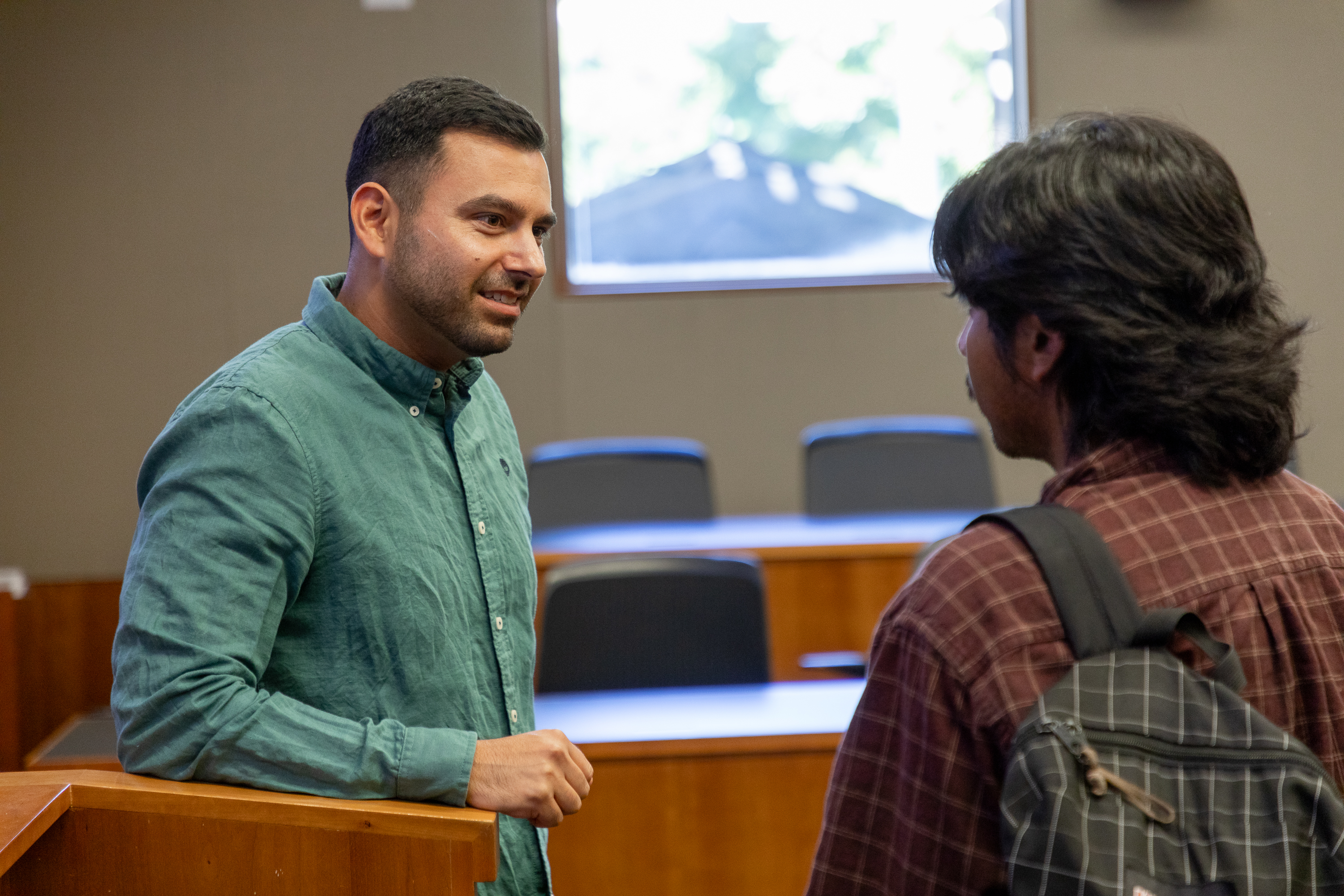 Michael V. Singh talking with a student