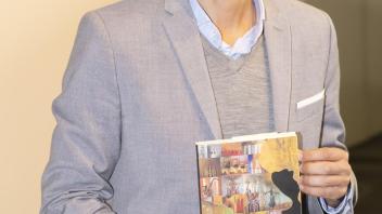Juan Diego poses with his book