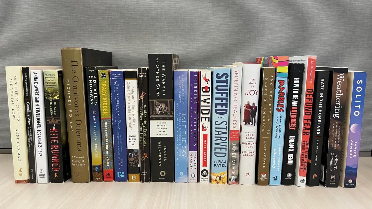 Book spines of the Campus Community Book Project selections from 2002 to 2025