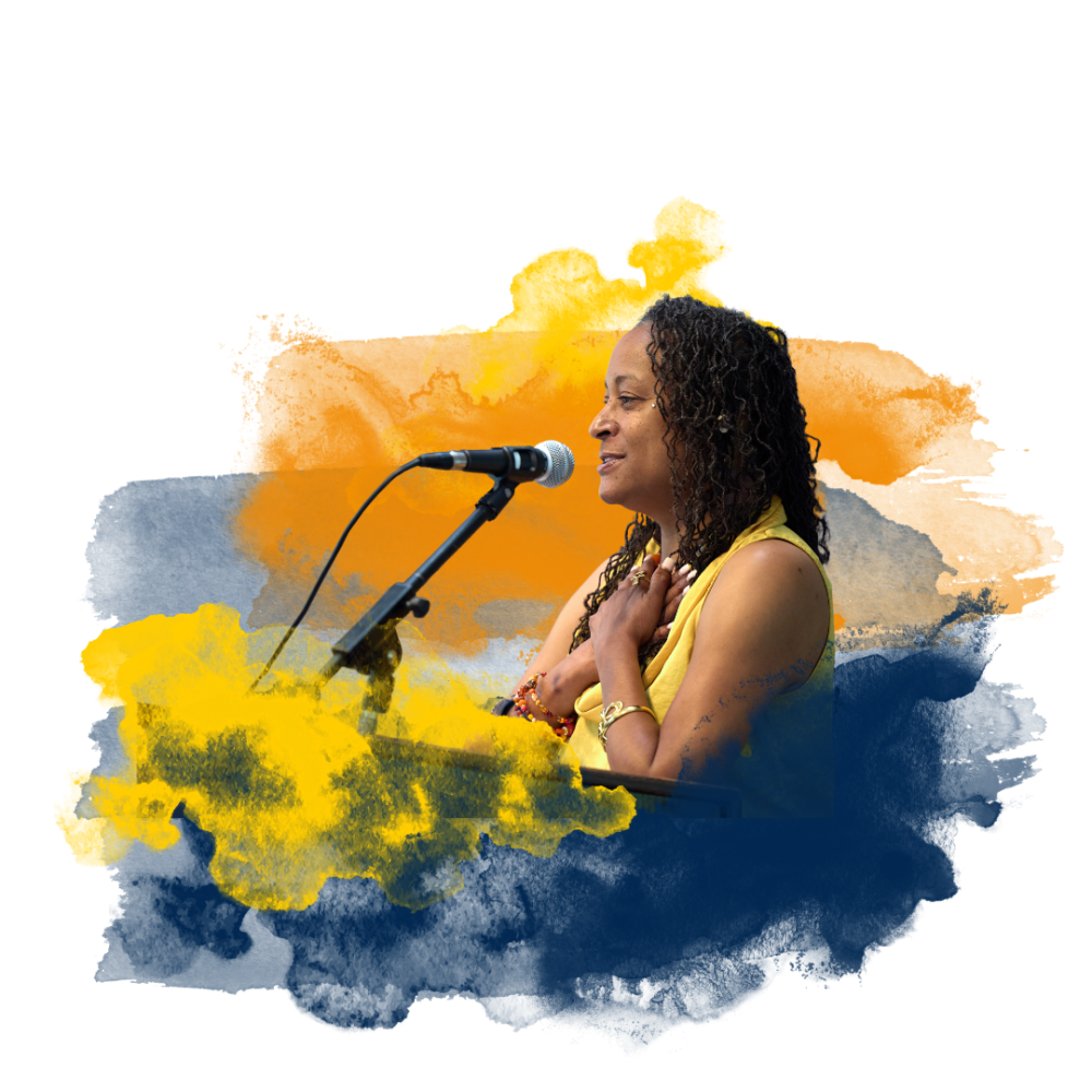 Woman speaking at a microphone with a colorful watercolor background.