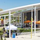 Outdoor event with orange and white tents at the Manetti Shrem Museum Plaza on a sunny day.