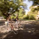 2 students riding on a pathway on campus