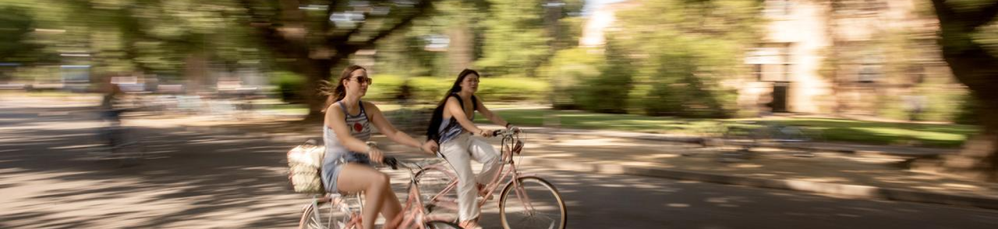 2 students riding on a pathway on campus